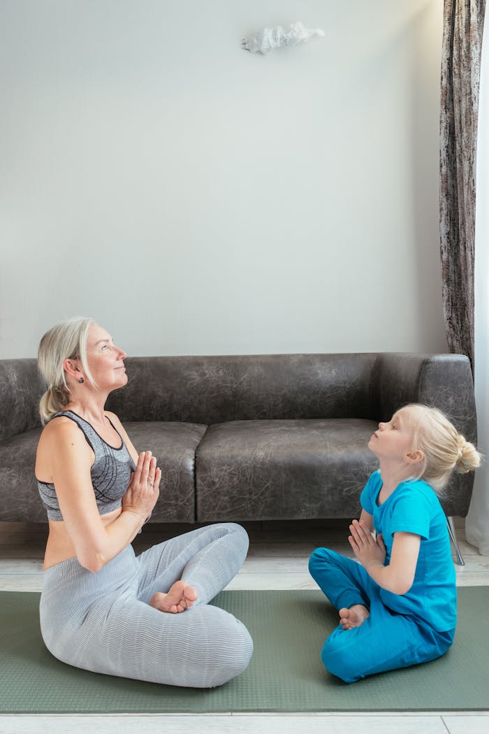 A woman and child practicing yoga indoors, fostering a peaceful family bond.